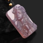 Angled view of the hand-carved purple agate Aries pendant showing the relief