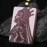 Hand-carved purple agate Leo zodiac necklace displayed on dark rock