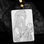 Hand-carved white agate Libra zodiac necklace displayed on dark rock