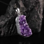 Close-up of the purple crystal surface and silver-tone edge of the raw amethyst necklace