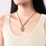 Raw fluorite necklace worn with a cream top, showing the pendant scale