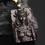 Hand-carved black obsidian Scorpio zodiac necklace displayed on dark rock