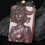 Hand-carved purple agate Taurus zodiac necklace displayed on dark rock