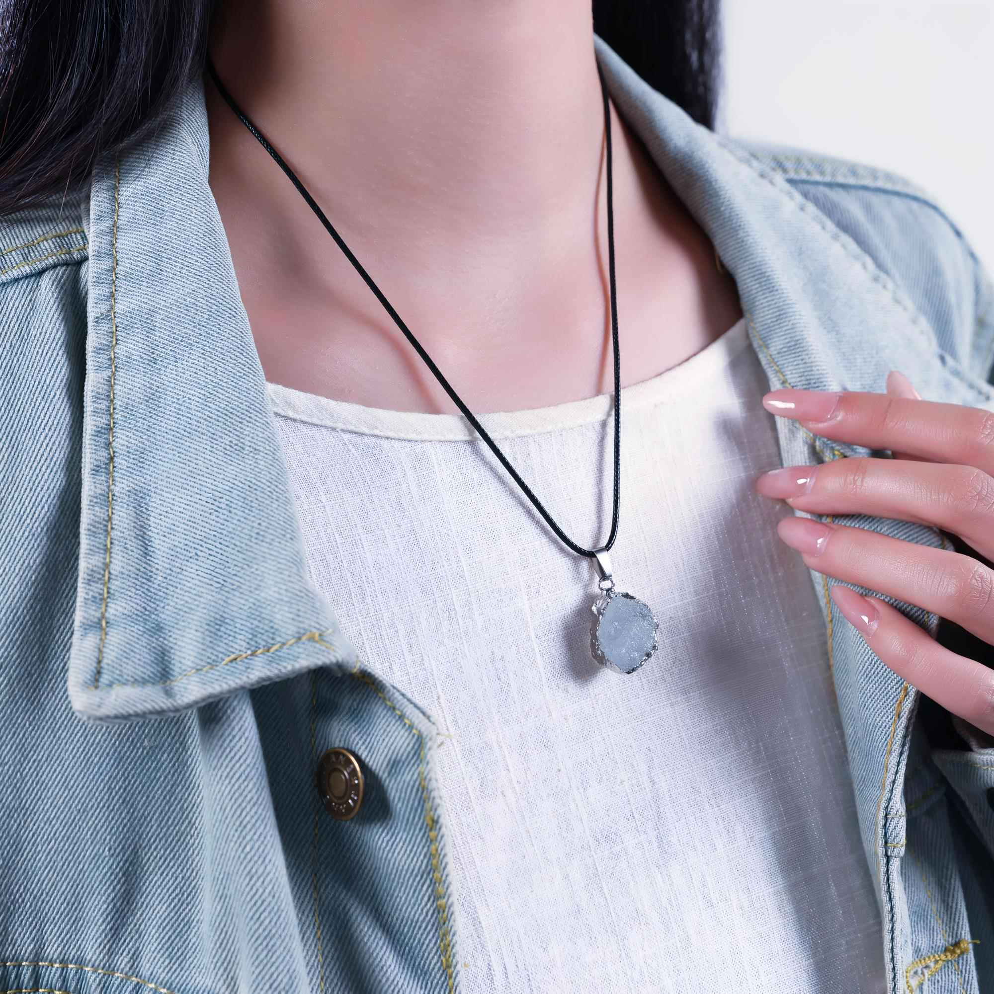 Raw aquamarine necklace worn with a denim jacket